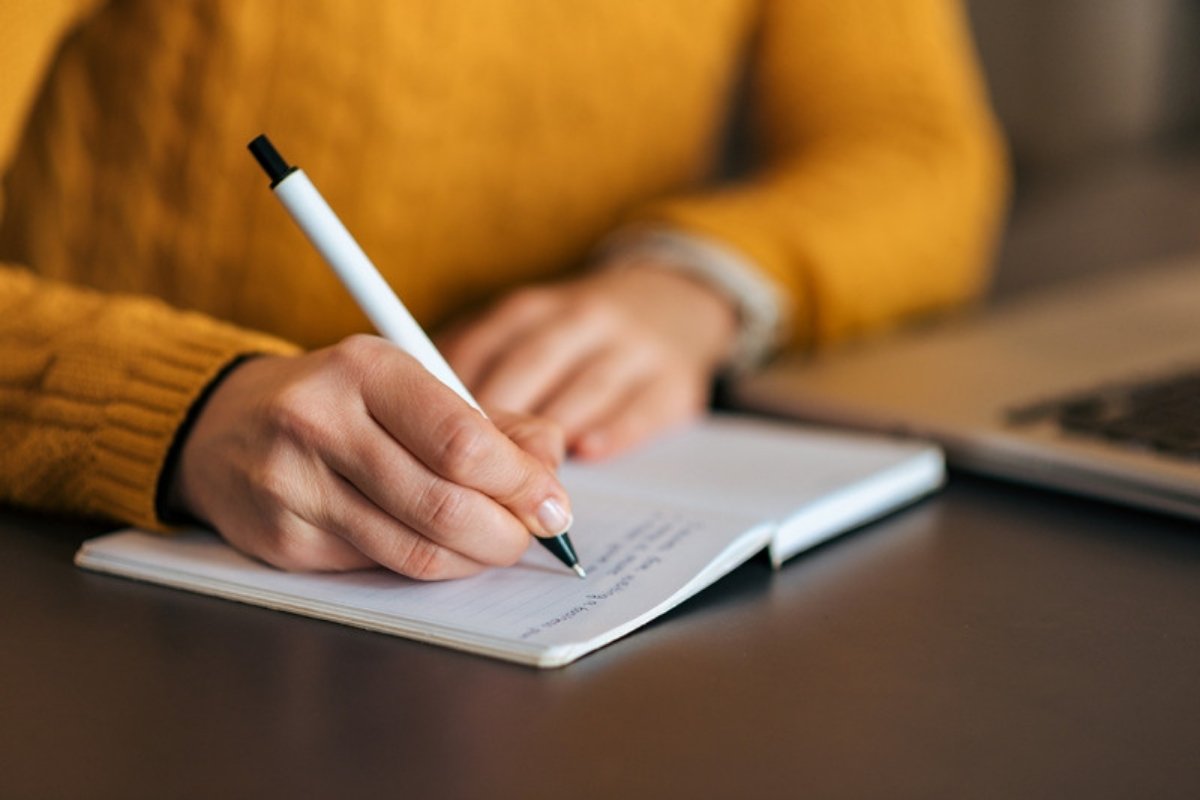 Close-up of a hand writing in a journal